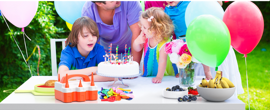 Children celebrating a birthday with a cake and colorful balloons inflated by the ETENWOLF pump