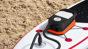 ETENWOLF S4 portable SUP pump connected to an inflatable paddle board on the beach