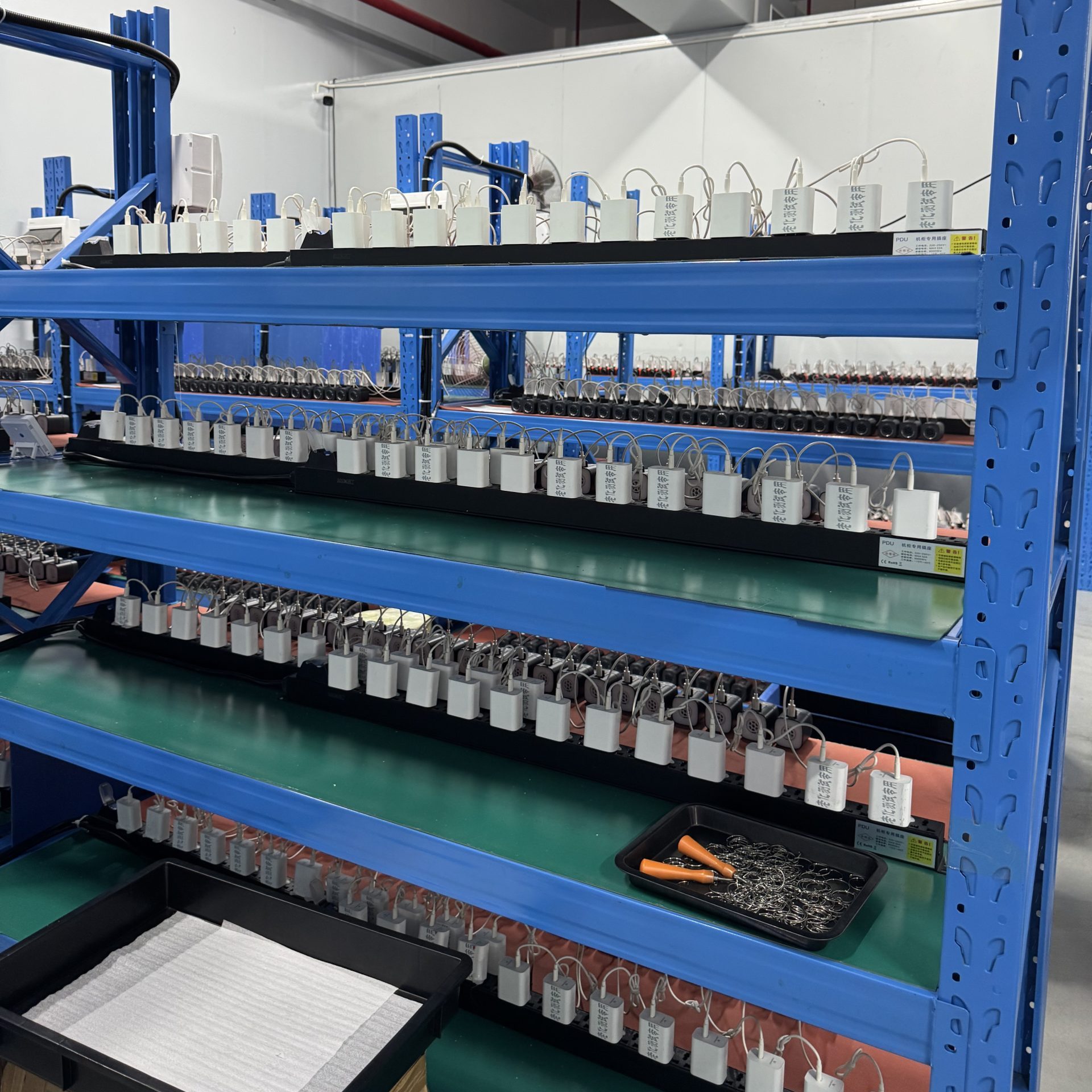 ETENWOLF Air3 products undergoing batch charging tests on aging racks in the factory workshop
