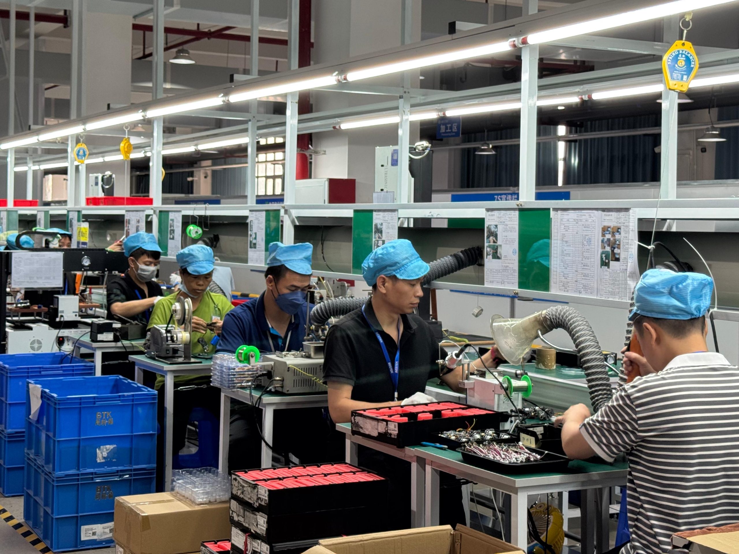 Finished portable air pumps arranged on an organized conveyor belt in the factory packaging zone