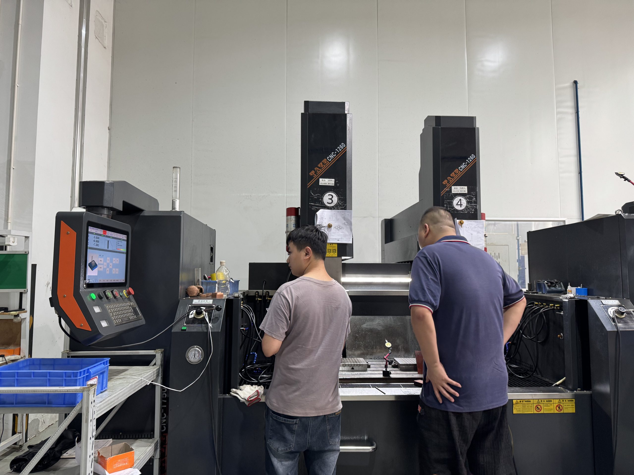 Operator working on the TAZE CNC-1260 double-head CNC EDM die sinking machine at the ETENWOLF factory.