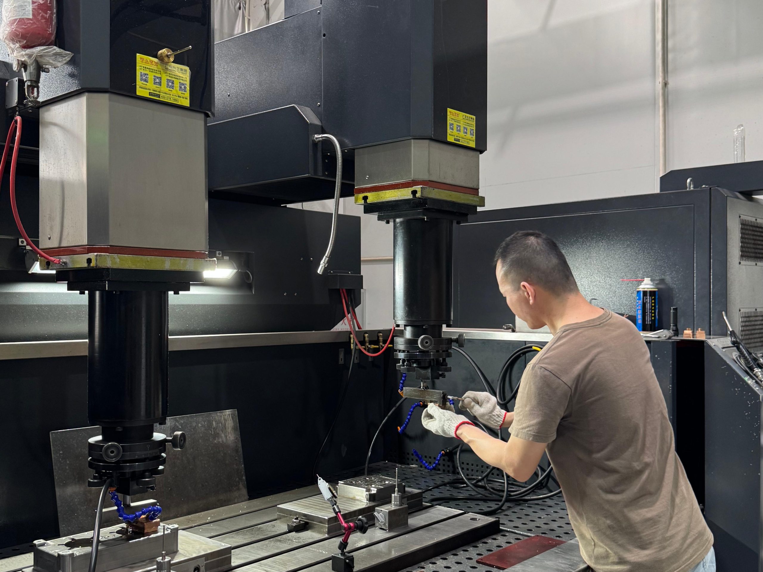 Experienced technician configuring a precision CNC EDM machine in the factory mold testing area