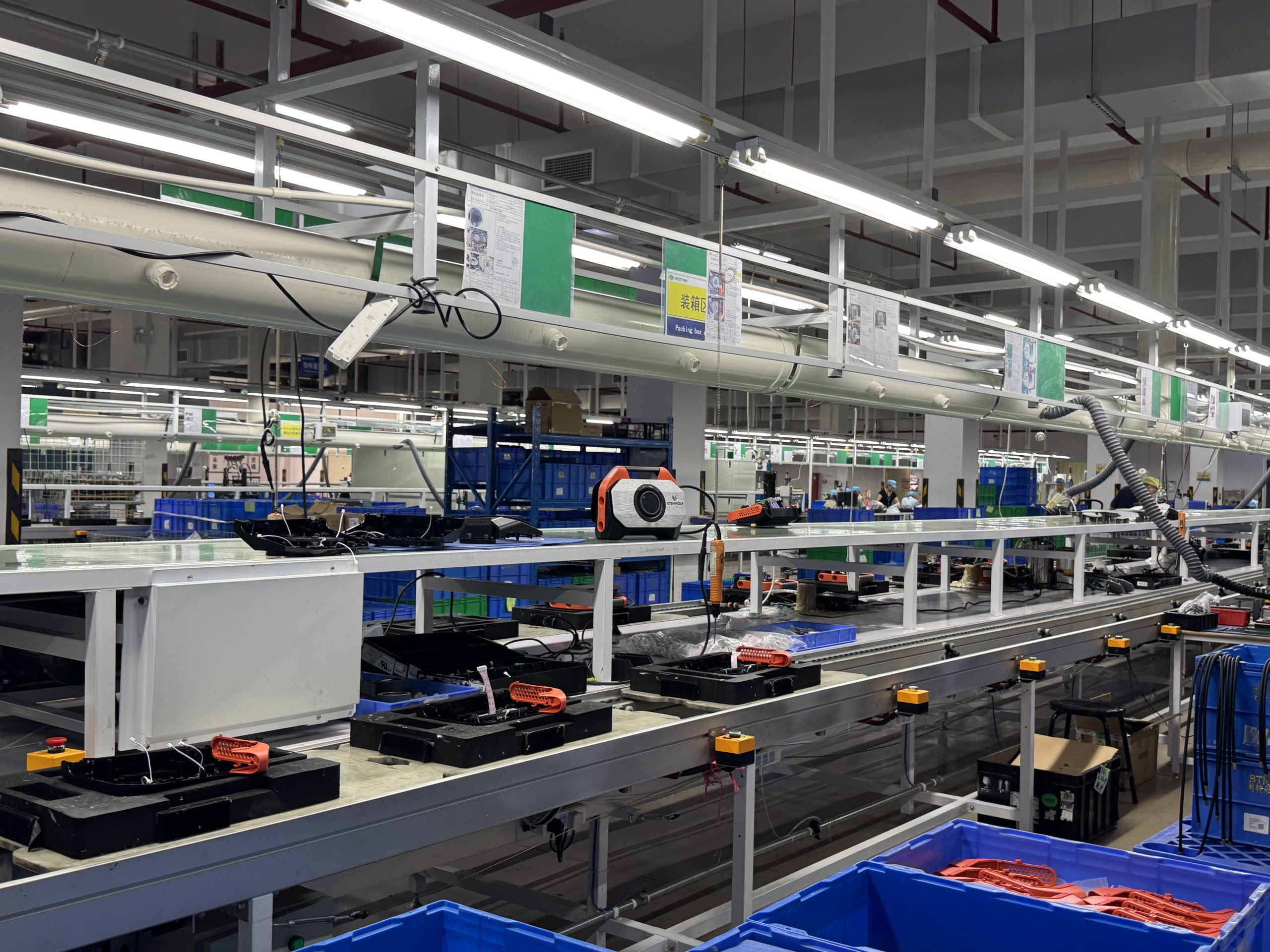 Finished portable air pumps arranged on an organized conveyor belt in the factory packaging zone