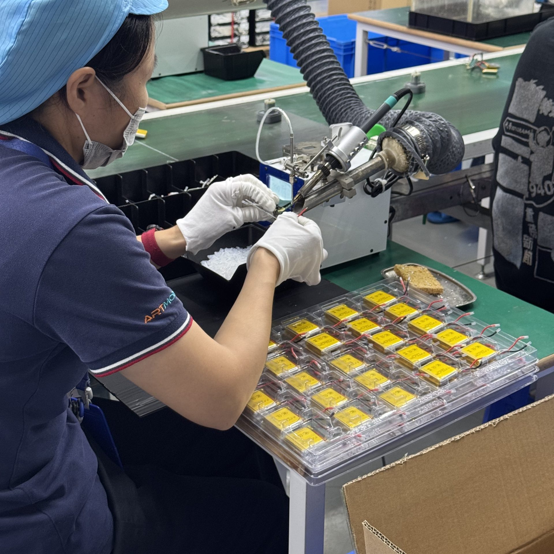An ETENWOLF factory worker using a semi-automatic soldering machine to solder internal PCBs and power wires of inflators