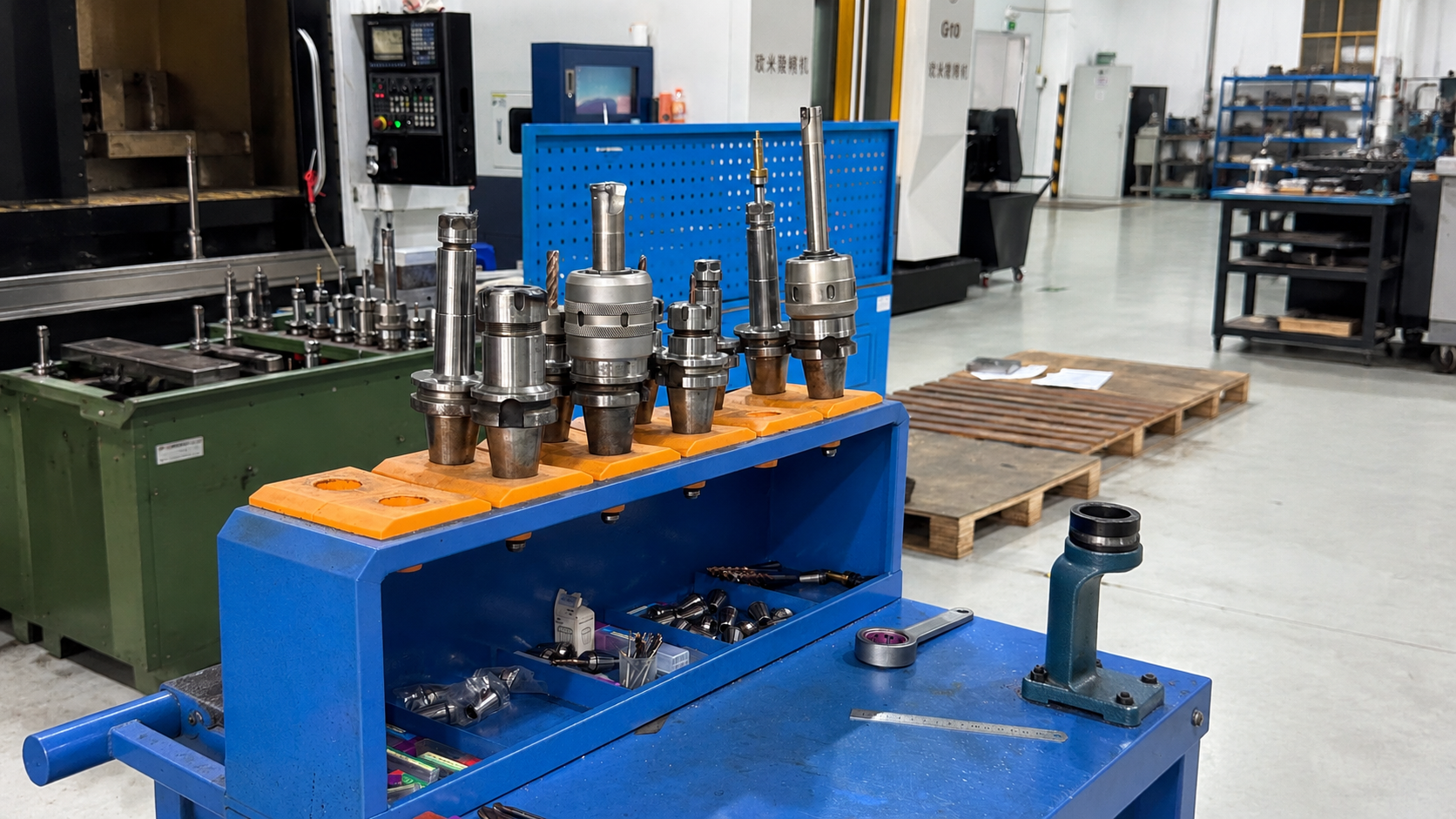 Detailed view of BT40 tool holders orange ABS inserts and locking fixture on CNC tool cart