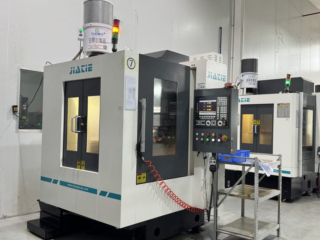 Side view of a high-speed CNC router machine equipped with an overhead oil mist collector and double enclosure doors.