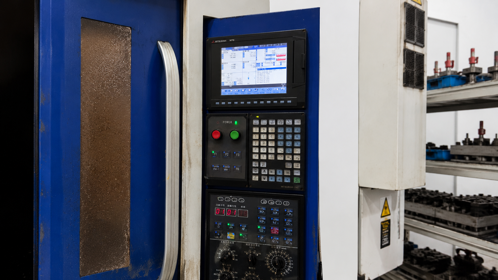 Close-up of the MITSUBISHI M70 CNC control panel and digital tool tracking display on a JMAST machine at ETENWOLF.